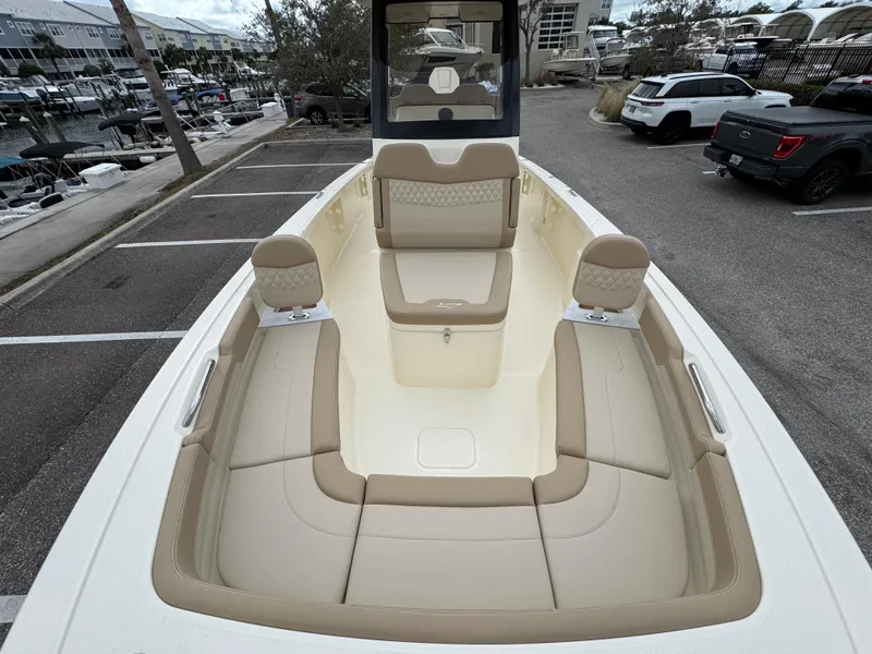 Slide: The Image of 2025 Scout 261 XSS boat with beige seating, docked in a marina parking area. - 25