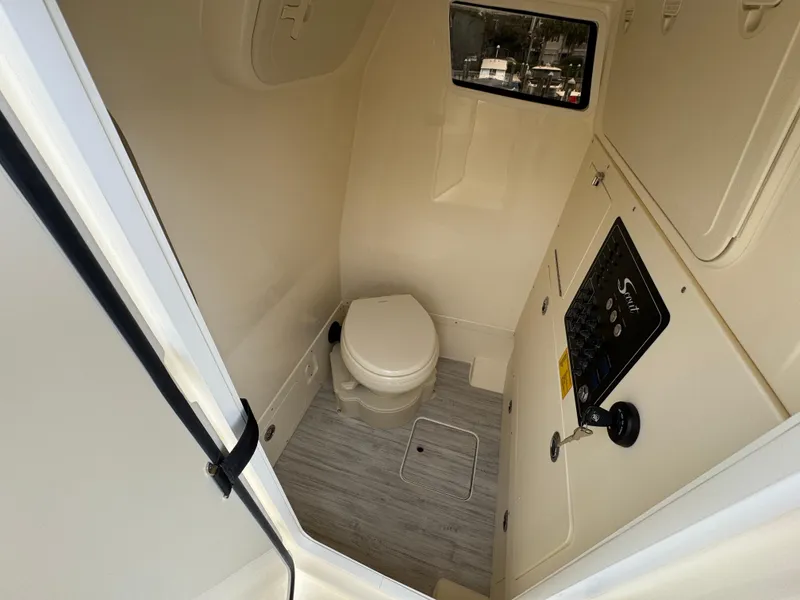 Slide: The Image of 2025 Scout 261 XSS boat interior bathroom with toilet and control panel. - 28