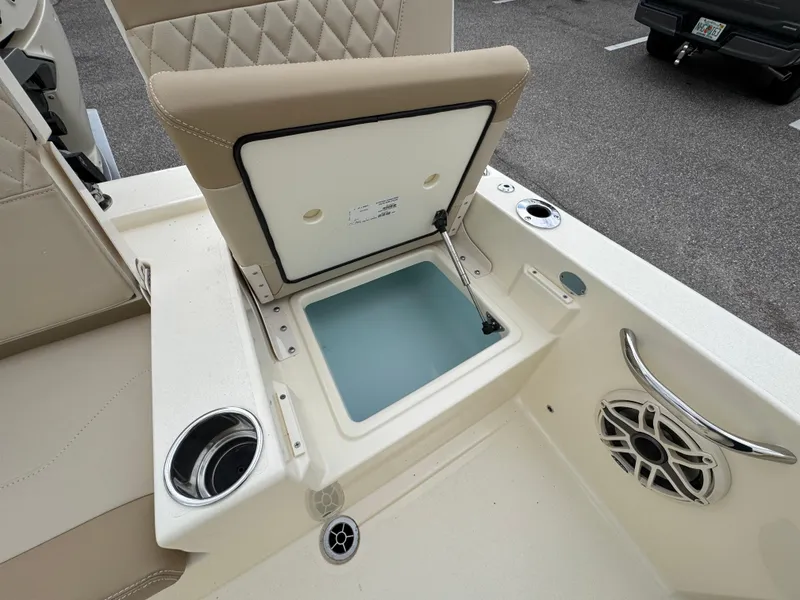 Slide: The Image of 2025 Scout 261 XSS boat interior with open storage compartment and speaker. - 7