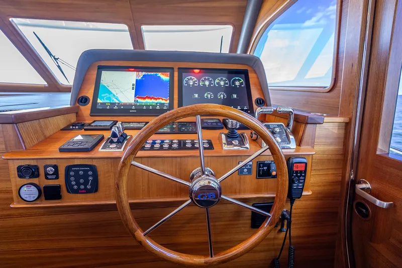 Slide: The Image of Helm of 2026 Grand Banks GB 54 yacht with wooden steering wheel and modern navigation displays. - 22