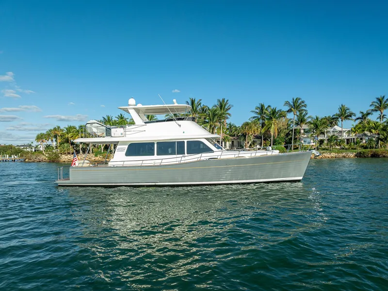 Slide: The Image of 2026 Grand Banks GB 54 yacht cruising on a sunny day, surrounded by palm trees. - 33