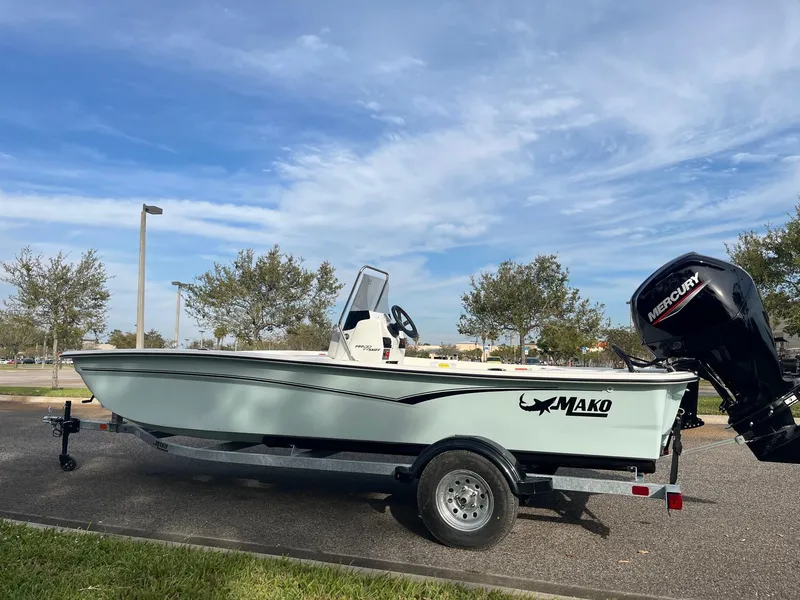 Slide: The Image of 2025 Mako Pro Skiff 17 CC boat on trailer, parked outdoors under a clear sky. - 0