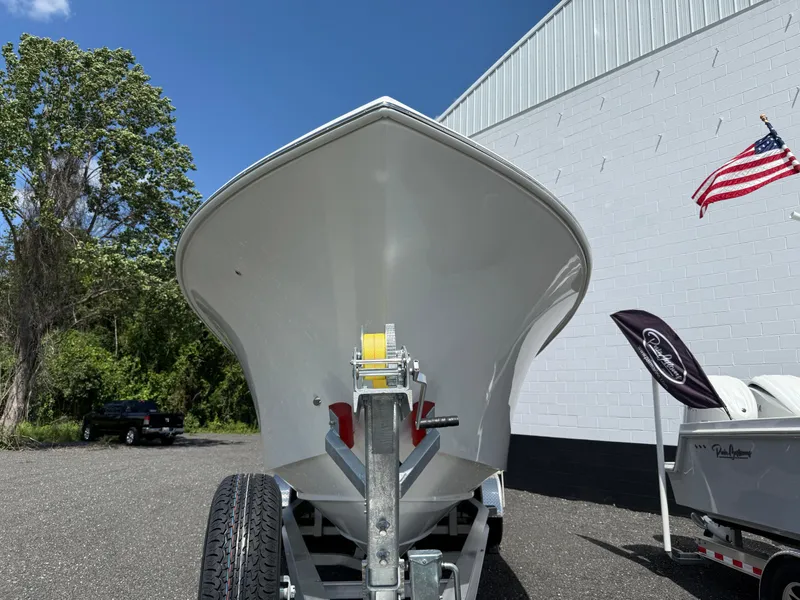 Slide: The Image of Front view of 2026 Pair Customs 28 boat on trailer, outdoors with American flag. - 2