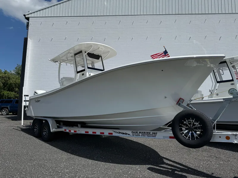 Slide: The Image of 2026 Pair Customs 28 boat on trailer, parked outdoors with American flag. - 3