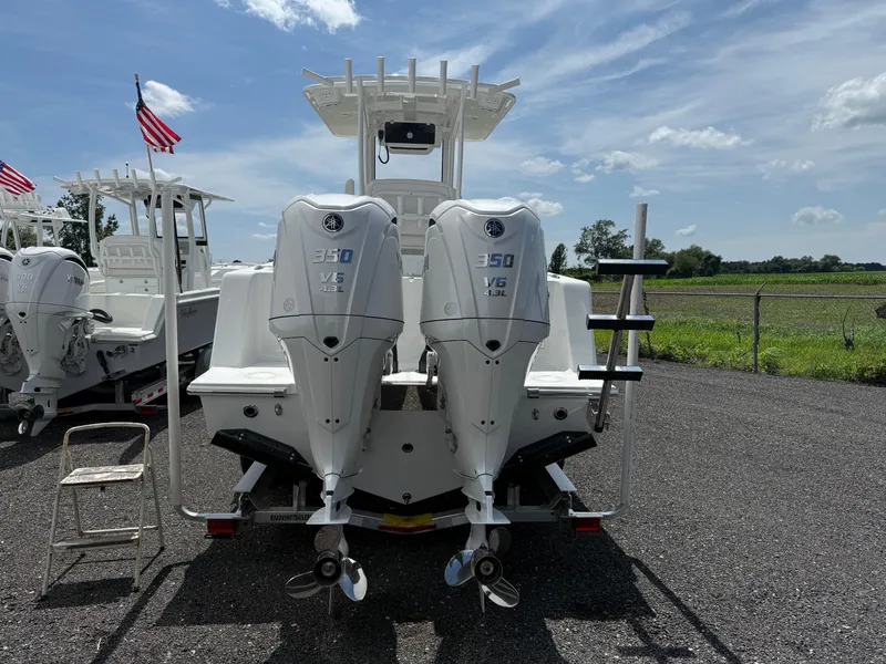 Slide: The Image of Twin Yamaha 350 V6 engines on a 2026 Pair Customs 28 boat, parked outdoors. - 4
