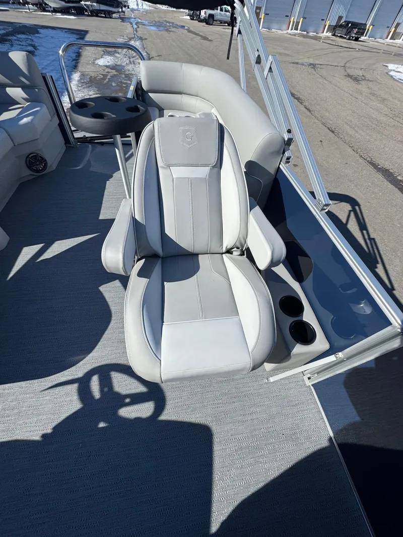 Slide: The Image of 2025 Xperience 2286 SBX boat interior with gray captain's chair and cup holders. - 11