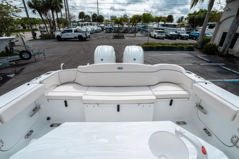 Slide: The Image of 2025 Sea Hunt Ultra 275 SE boat interior with seating and dual engines in a parking lot. - 10