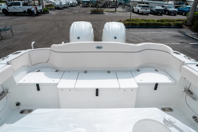Slide: The Image of 2025 Sea Hunt Ultra 275 SE boat interior with dual engines, parked in a marina. - 13