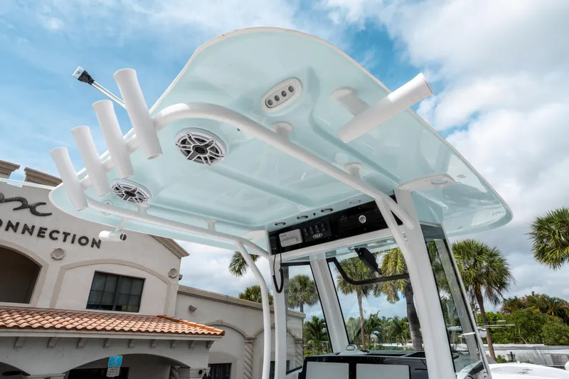 Slide: The Image of 2025 Sea Hunt Ultra 275 SE boat with T-top and rod holders, under a cloudy sky. - 21