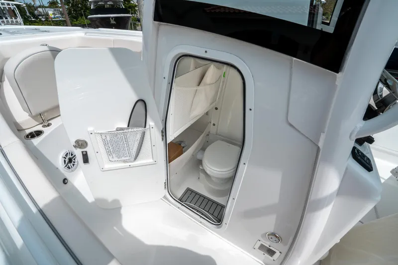 Slide: The Image of 2025 Sea Hunt Ultra 275 SE boat interior with open bathroom door. - 30