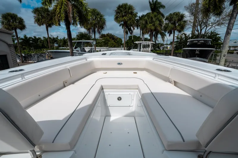 Slide: The Image of 2025 Sea Hunt Ultra 275 SE boat interior with white seating and palm trees in background. - 33