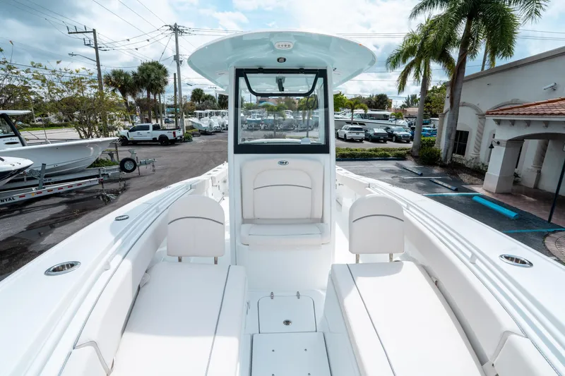 Slide: The Image of 2025 Sea Hunt Ultra 275 SE boat, white interior, parked outdoors with palm trees. - 35