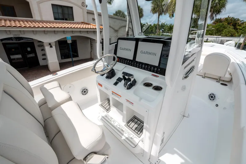 Slide: The Image of 2025 Sea Hunt Ultra 275 SE boat interior with Garmin displays and steering wheel. - 24