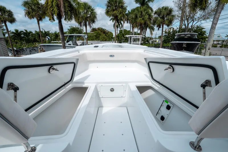 Slide: The Image of 2025 Sea Hunt Ultra 275 SE boat interior with open storage compartments, surrounded by palm trees. - 37