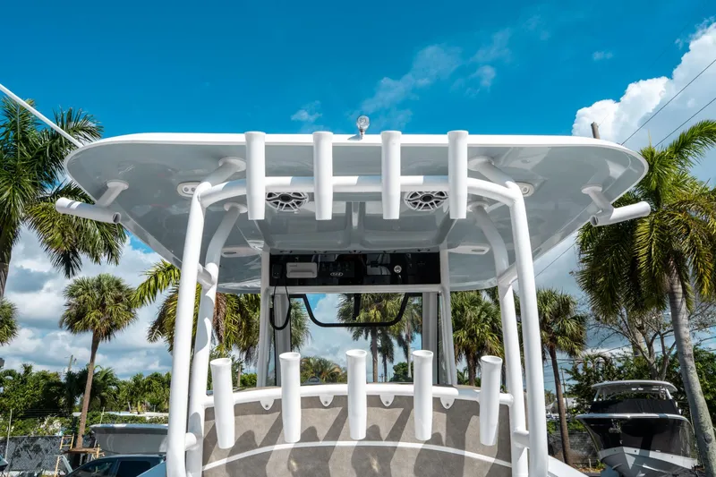 Slide: The Image of 2025 Sea Hunt Gamefish 30 CB boat with rod holders, under a clear blue sky. - 21