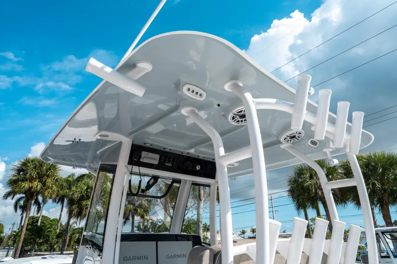 Slide: The Image of 2025 Sea Hunt Gamefish 30 CB boat with T-top and rod holders under blue sky. - 23