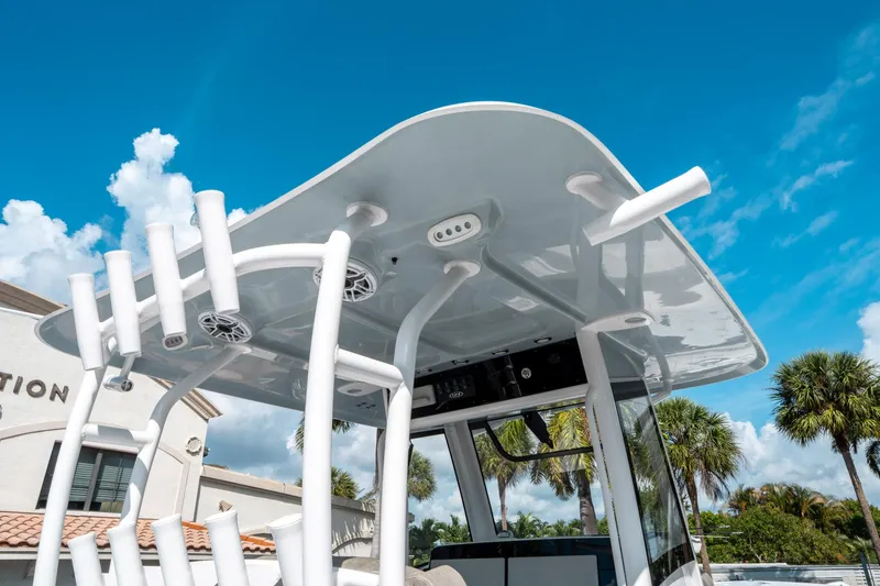 Slide: The Image of 2025 Sea Hunt Gamefish 30 CB boat with T-top and rod holders under a clear blue sky. - 22