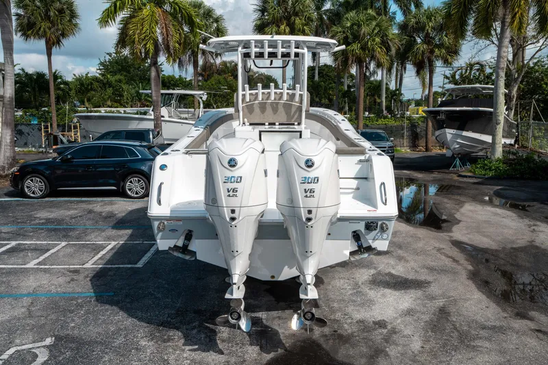 Slide: The Image of 2025 Sea Hunt Gamefish 30 CB with dual 300 V6 engines, parked near palm trees. - 3