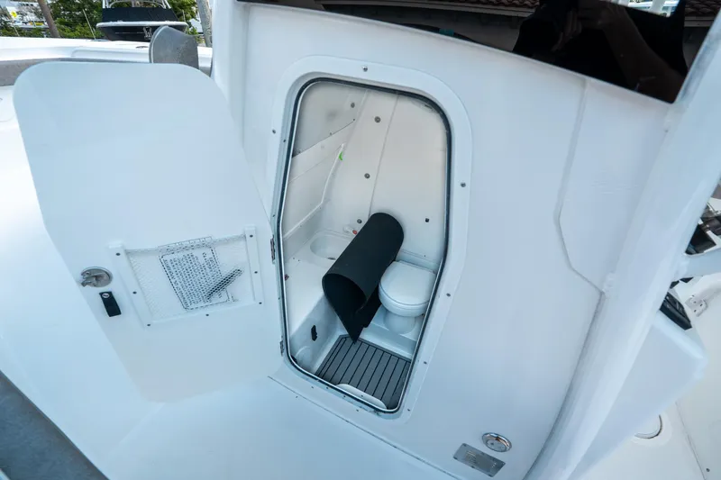 Slide: The Image of 2025 Sea Hunt Gamefish 30 CB boat interior with open door showing compact bathroom. - 33