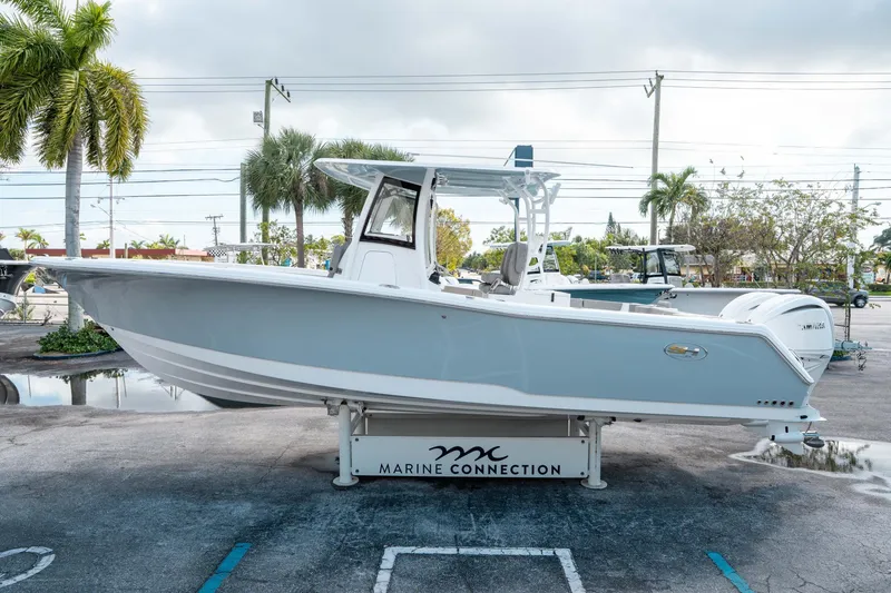 Slide: The Image of 2025 Sea Hunt Gamefish 30 CB boat displayed outdoors with palm trees in the background. - 5