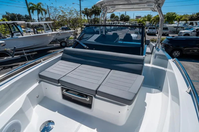 Slide: The Image of 2025 Quarken 27 T-Top boat with sleek seating and modern design in a sunny marina. - 19