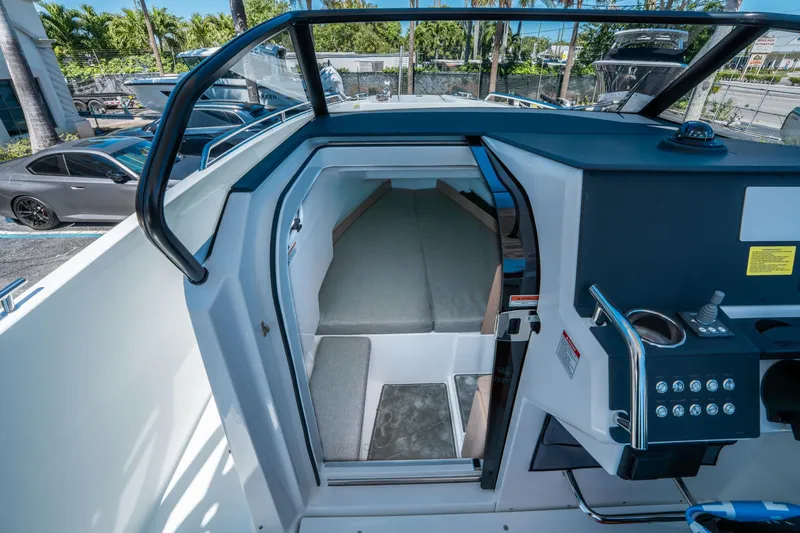 Slide: The Image of Interior view of 2025 Quarken 27 T-Top boat cabin with modern controls. - 23
