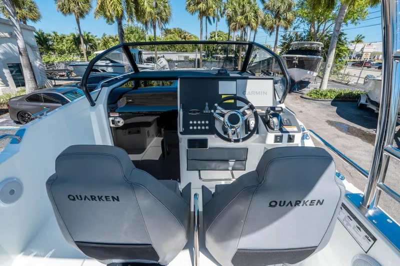 Slide: The Image of 2025 Quarken 27 T-Top boat cockpit with steering wheel and Garmin navigation system. - 13