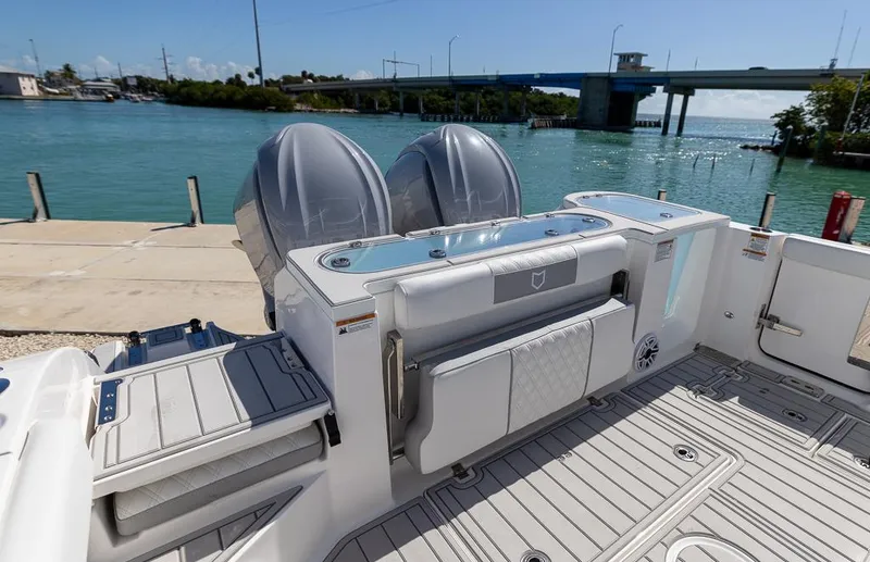 Slide: The Image of 2025 Sea Fox 328 Commander boat docked by a scenic waterfront bridge. - 10