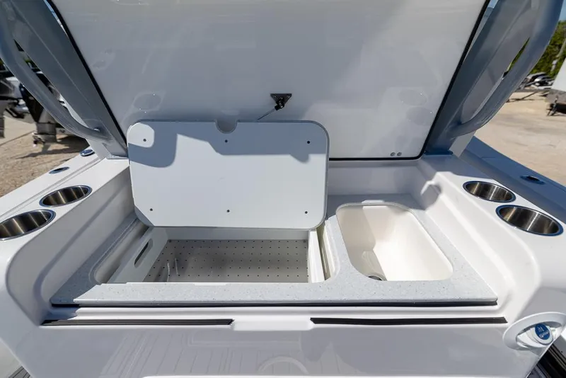 Slide: The Image of 2025 Sea Fox 328 Commander boat storage compartment with open lid and cup holders. - 13