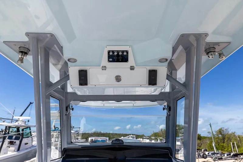 Slide: The Image of 2025 Sea Fox 328 Commander boat console with speakers and controls, under clear blue sky. - 16
