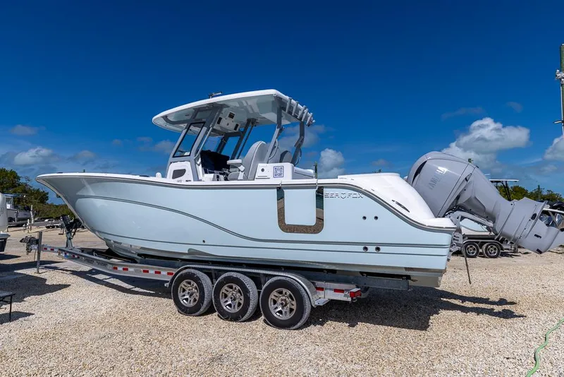 Slide: The Image of 2025 Sea Fox 328 Commander boat on trailer, side view, clear sky background. - 2