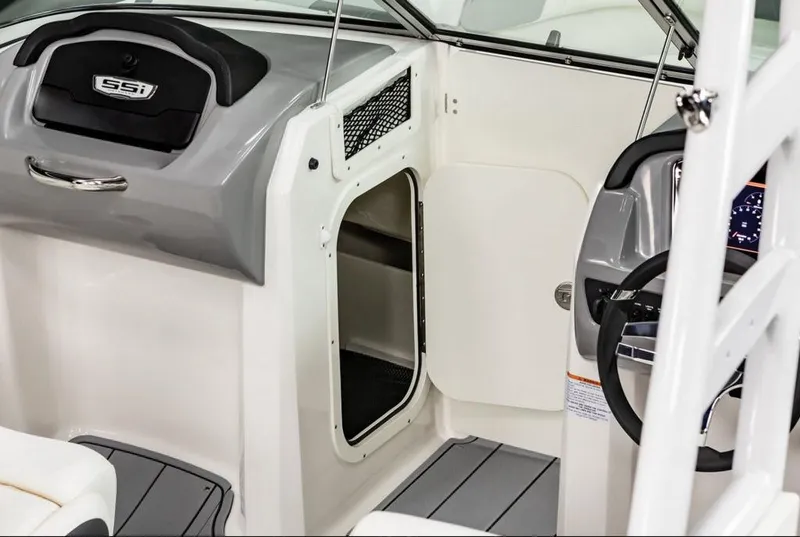 Slide: The Image of 2025 Chaparral 23 SSi OB boat interior with helm and storage compartment. - 4
