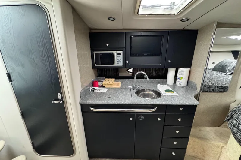 Slide: The Image of 2005 Formula 34 Performance Cruiser interior kitchen with sink, microwave, and storage cabinets. - 36