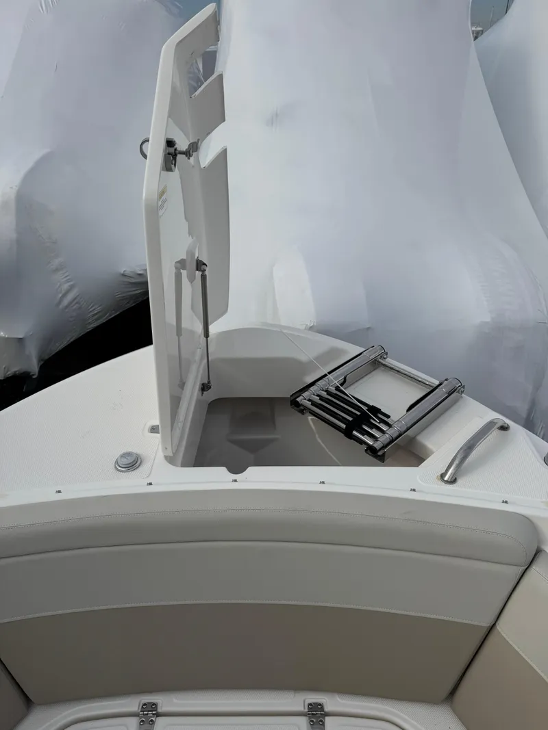 Slide: The Image of 2022 Boston Whaler 240 Vantage boat with open storage compartment and ladder. - 8