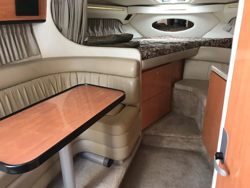 Slide: The Image of 1999 Regal 322 Commodore cabin interior with seating, table, and bed. - 4