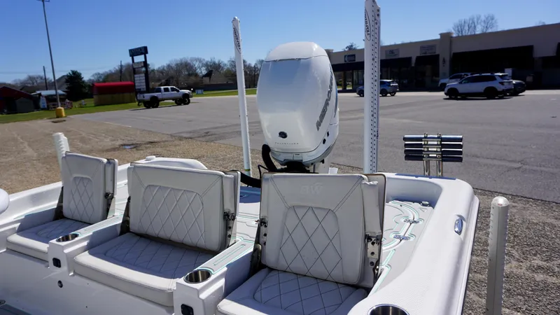 Slide: The Image of 2022 Blue Wave 2600 PureBay boat with white seating and motor in a parking lot. - 13