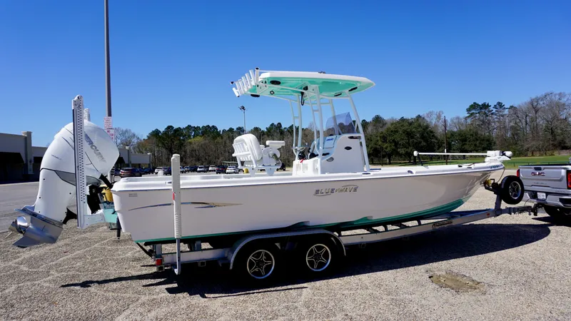 Slide: The Image of 2022 Blue Wave 2600 PureBay boat on trailer in parking lot, clear sky background. - 3