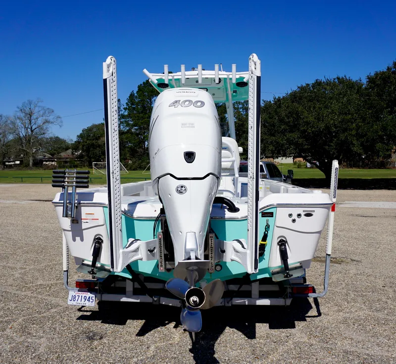 Slide: The Image of 2022 Blue Wave 2600 PureBay boat with powerful outboard motor, parked outdoors. - 5