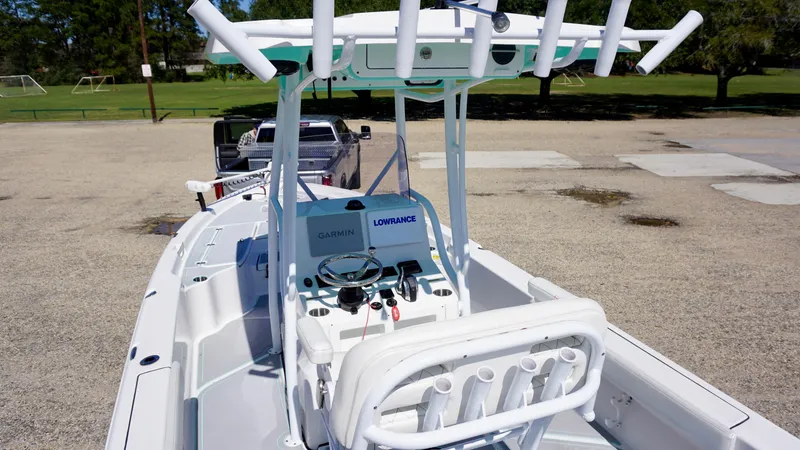 Slide: The Image of 2022 Blue Wave 2600 PureBay boat with advanced navigation equipment, parked on a gravel surface. - 8