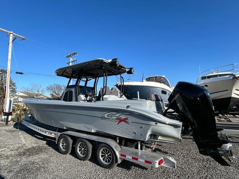 Slide: The Image of 2024 Glasstream 32 GSX boat on trailer, parked outdoors under clear blue sky. - 8