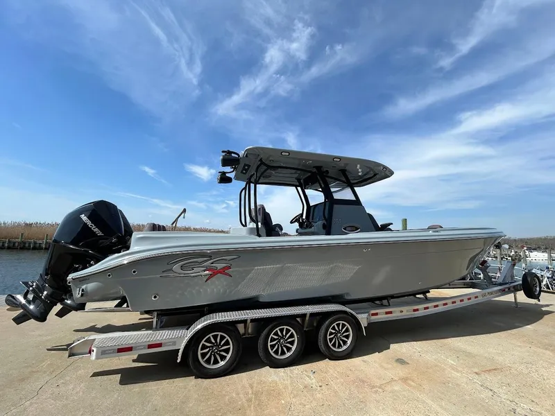 The Image of 2024 Glasstream 32 GSX boat on a trailer under a clear blue sky. - 0