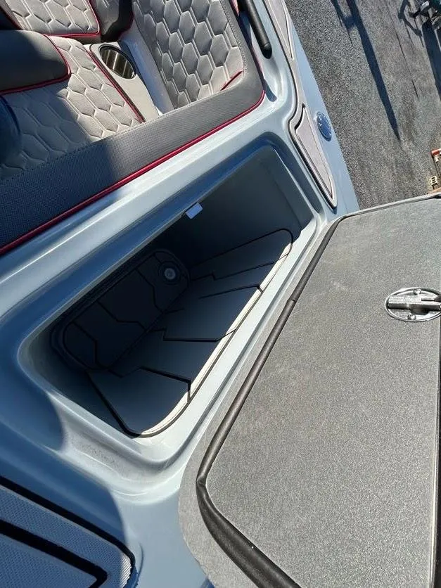 Slide: The Image of 2024 Glasstream 32 GSX boat storage compartment with open lid and cushioned seating. - 28