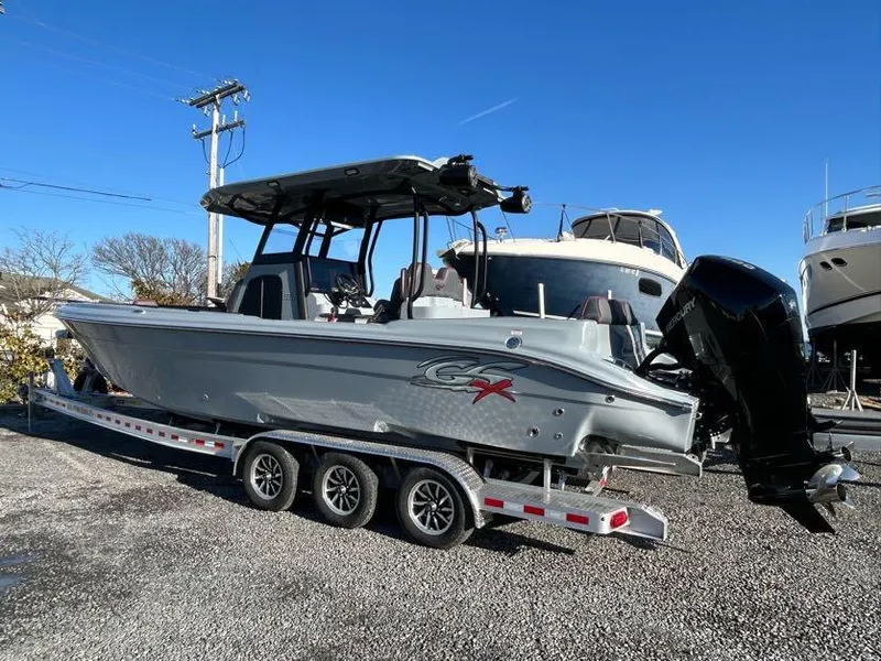 Slide: The Image of 2024 Glasstream 32 GSX boat on trailer, parked outdoors under clear blue sky. - 6