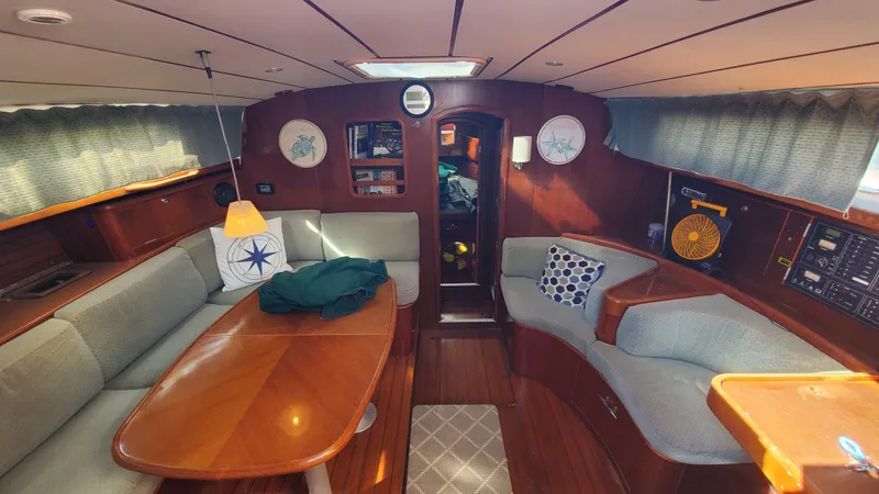 Slide: The Image of Interior of 1999 Beneteau Oceanis 44 CC sailboat with cozy seating and wooden finishes. - 13