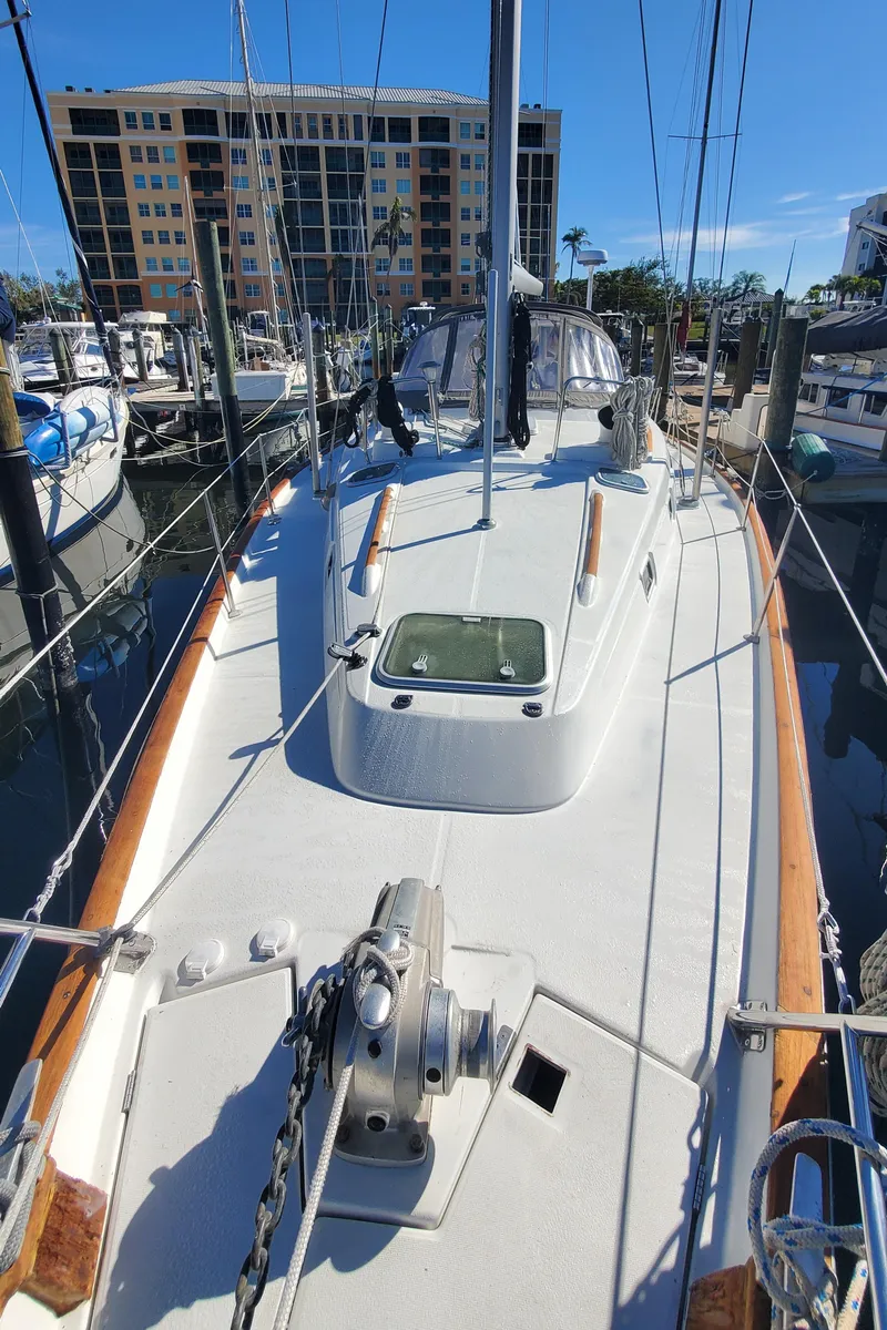 Slide: The Image of 1999 Beneteau Oceanis 44 CC sailboat docked at marina, sunny day, modern buildings in background. - 24