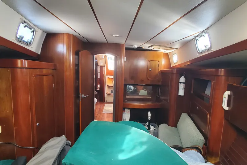 Slide: The Image of Interior of 1999 Beneteau Oceanis 44 CC yacht with wooden furnishings and green upholstery. - 29