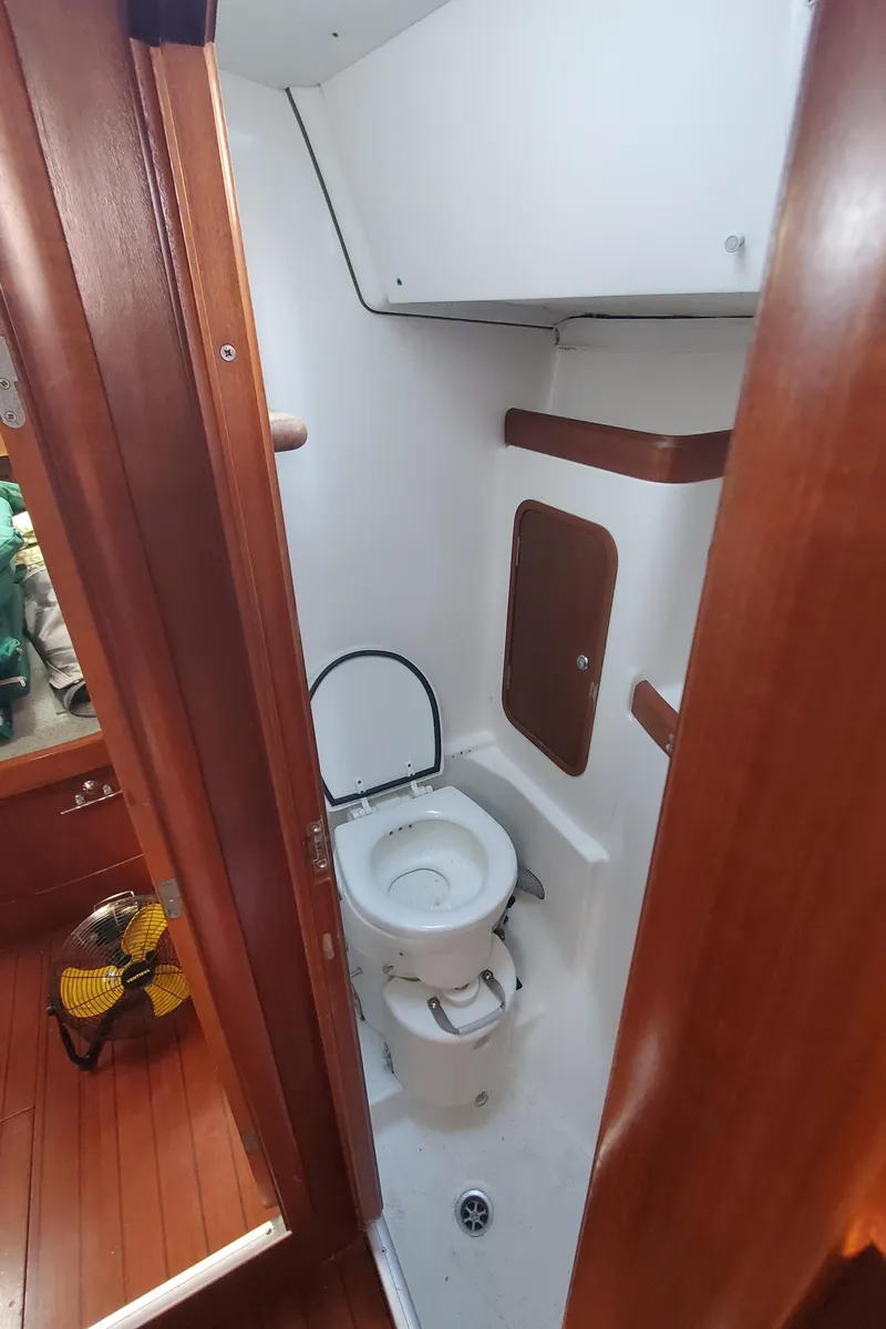 Slide: The Image of 1999 Beneteau Oceanis 44 CC yacht bathroom with wooden accents and compact design. - 31