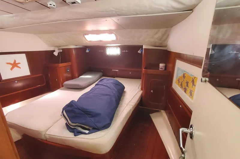 Slide: The Image of Cozy cabin interior of 1999 Beneteau Oceanis 44 CC sailboat with bed and wooden furnishings. - 33