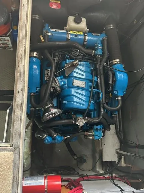 Slide: The Image of Engine compartment of a 1998 Silverton 372 Motor Yacht, featuring a blue marine engine. - 26