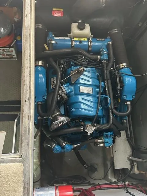 Slide: The Image of Engine compartment of a 1998 Silverton 372 Motor Yacht, featuring a blue marine engine. - 27